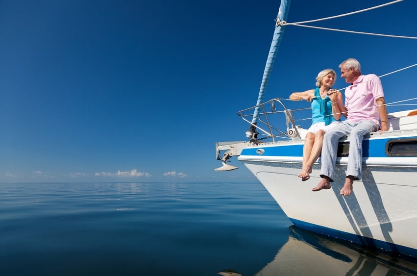 A happy senior couple sitting on the front of a sail