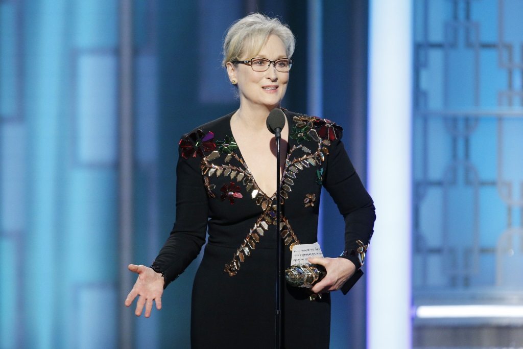 Meryl Streep holding an award and speaking into a microphone
