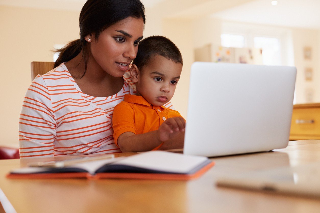 Mother and son in kitchen on laptop