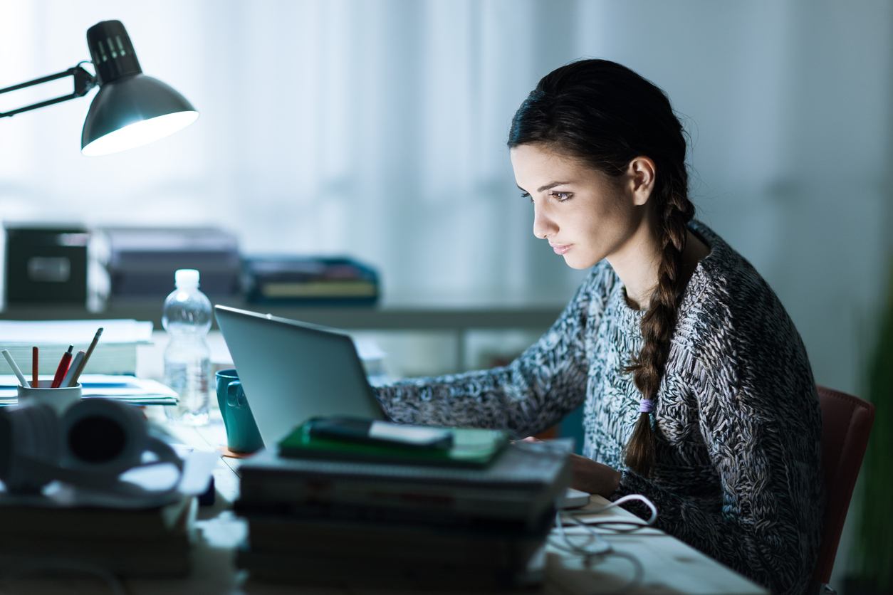 young student sitting at desk and doing her homework