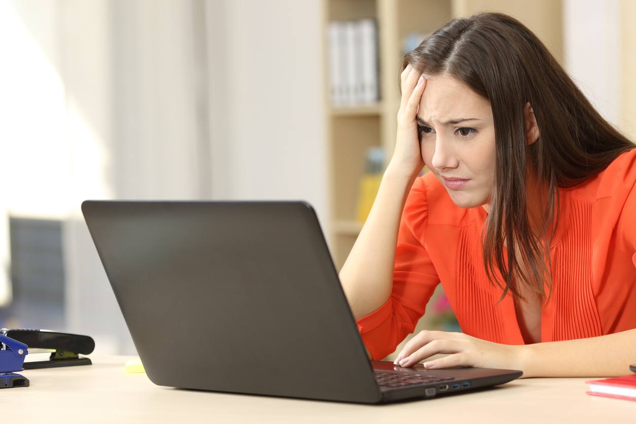 Sad and worried entrepreneur working on line with a laptop