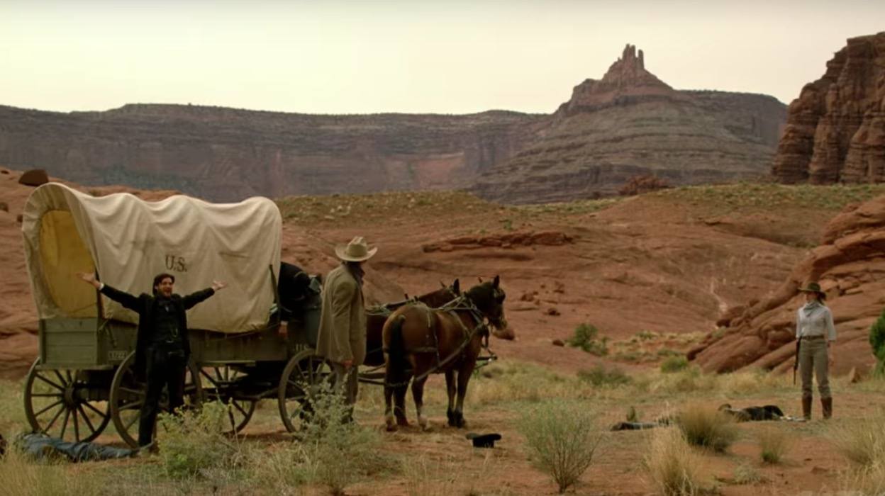 Logan (Ben Barnes), William (Jimmi Simpson) and Dolores (Evan Rachel Wood) stand outside near a covered wagon in a scene from 'Westworld'