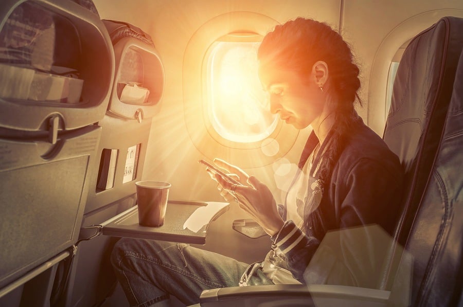 Woman using smartphone at airplane