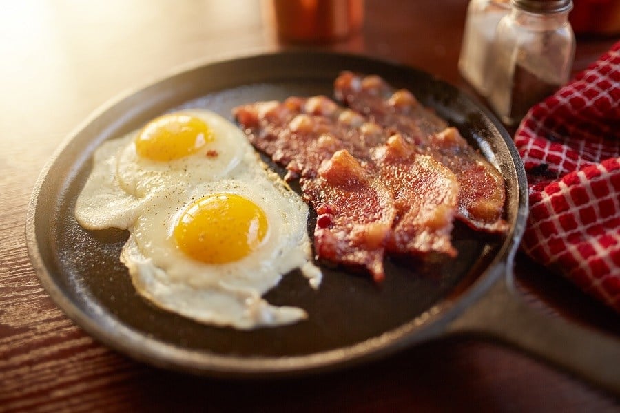 Bacon and sunny side up eggs in iron skillet