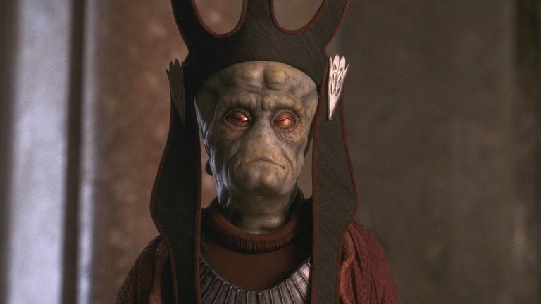 Nute Gunray, wearing a black crowned hat, and a red robe