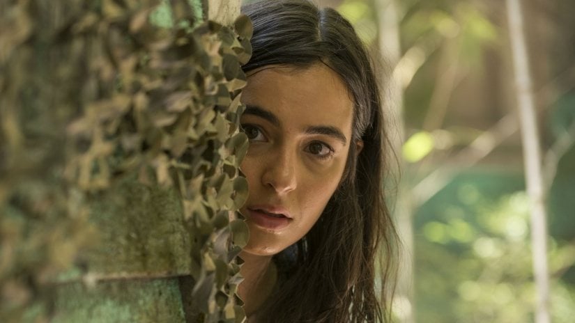 Tara peers around a tree in a scene from 'The Walking Dead's seventh season.