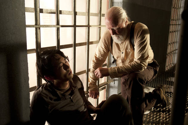 Hershel (Scott Wilson) treats a sick Glenn (Steven Yeun) in a scene from Season 4 of 'The Walking Dead'