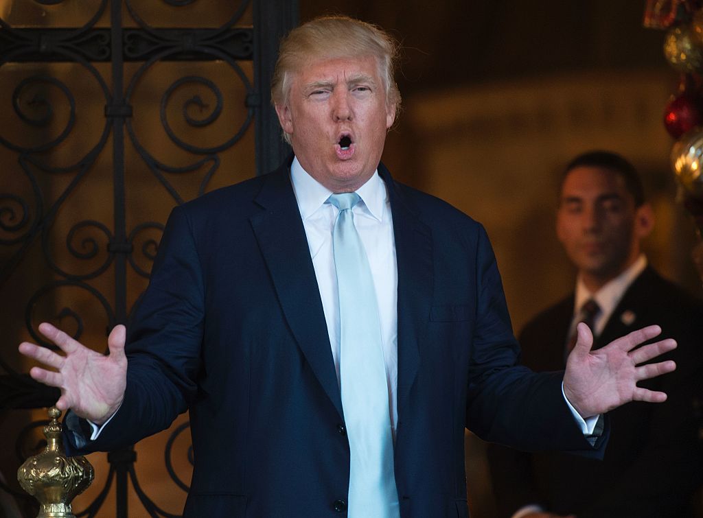 Donald Trump speaks while holding his hands out on either side