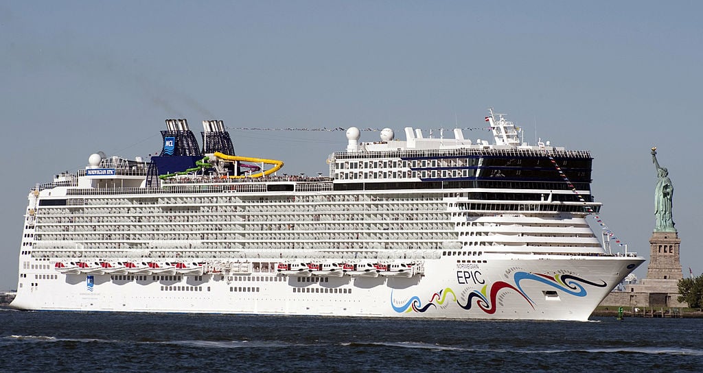 The Norwegian Epic, one of the top 10 largest cruise ships in the world, dwarfs the Statue of Liberty as it sails past.