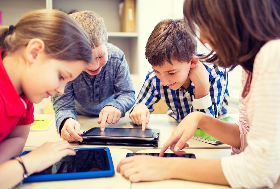 A group of students works on their tablets