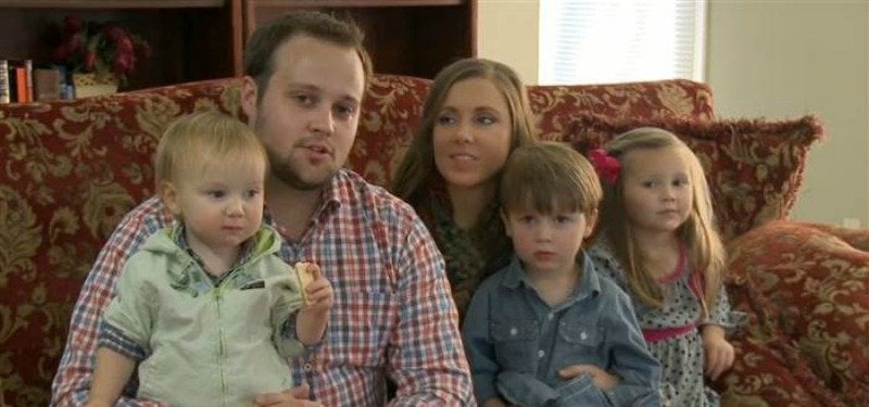 Josh Duggar and his wife are sitting on the couch holding two children on 19 and Counting.