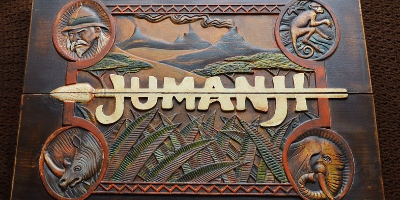 The outside of the game box for Jumanji, with the logo on the front with an arrow through the letters