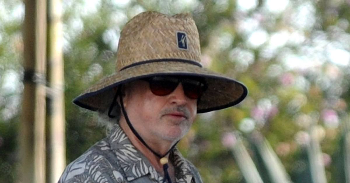 Terrence Malick wearing a wide-brimmed straw hat and sunglasses