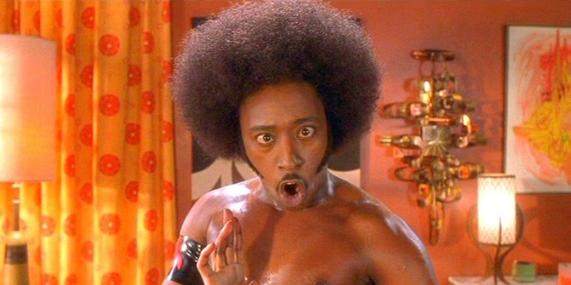 Eddie Griffin is posing shirtless with an afro in Undercover Brother.