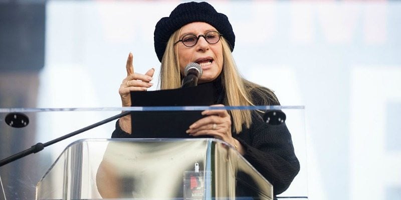Barbra Streisand talking at a podium while wearing black