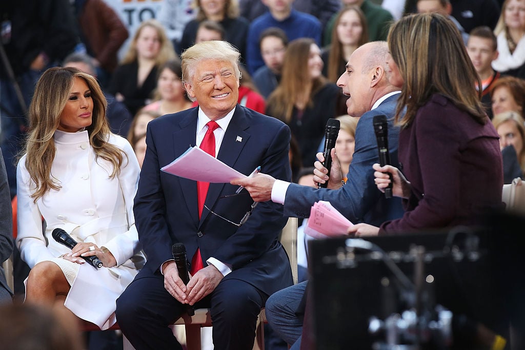 Donald Trump sits with his wife Melania Trump