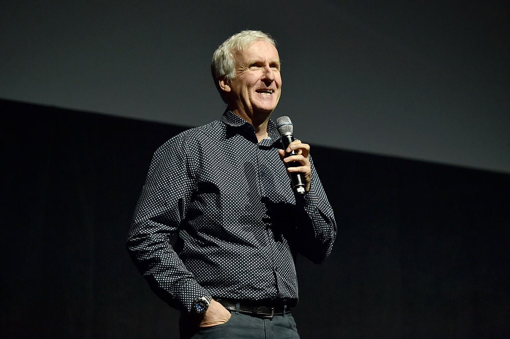 James Cameron wearing a black dress shirt, speaking into a microphone