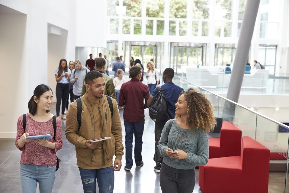 Students holding tablets in university lobby