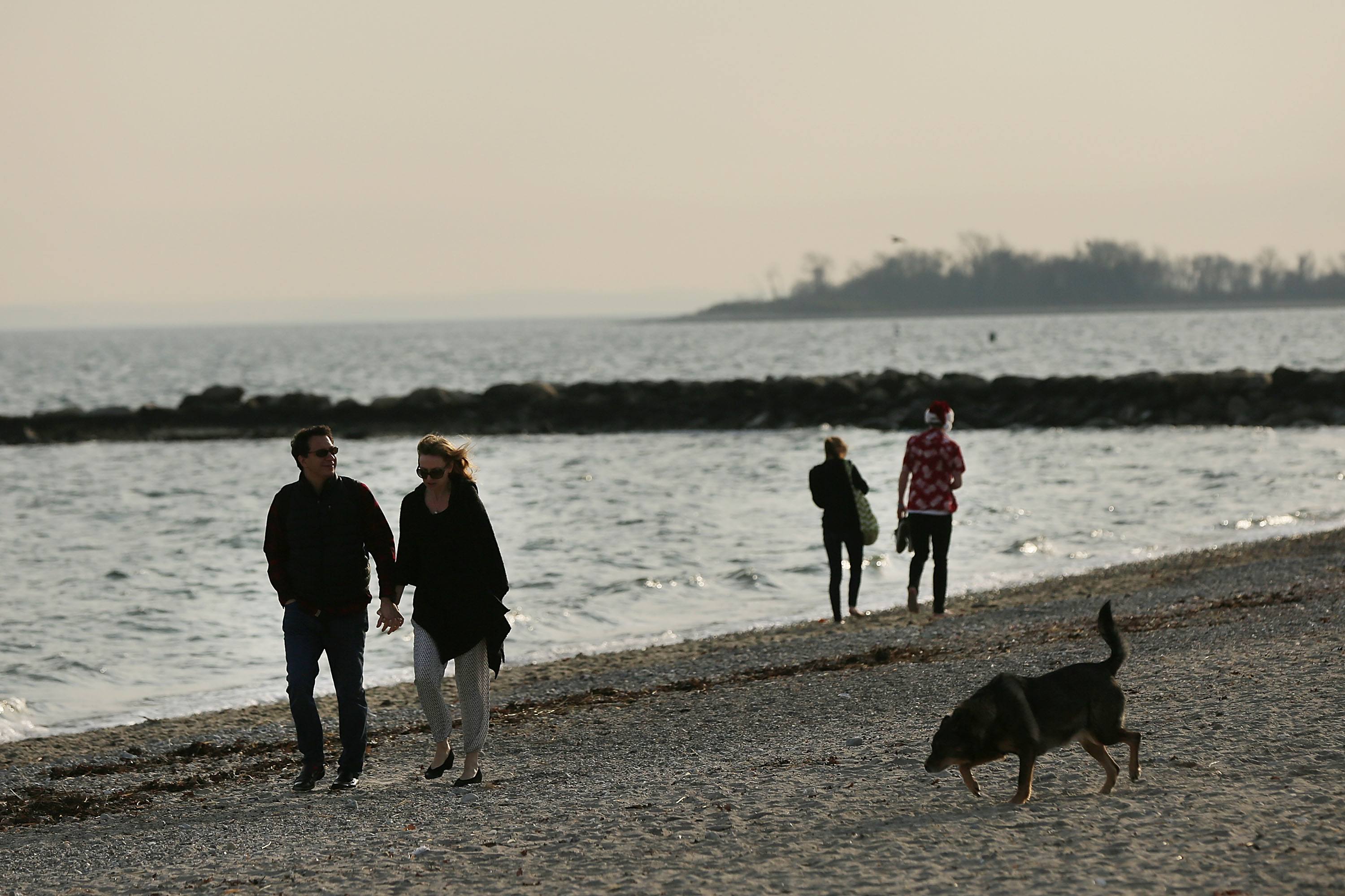 Couples walk along a Connecticut beach