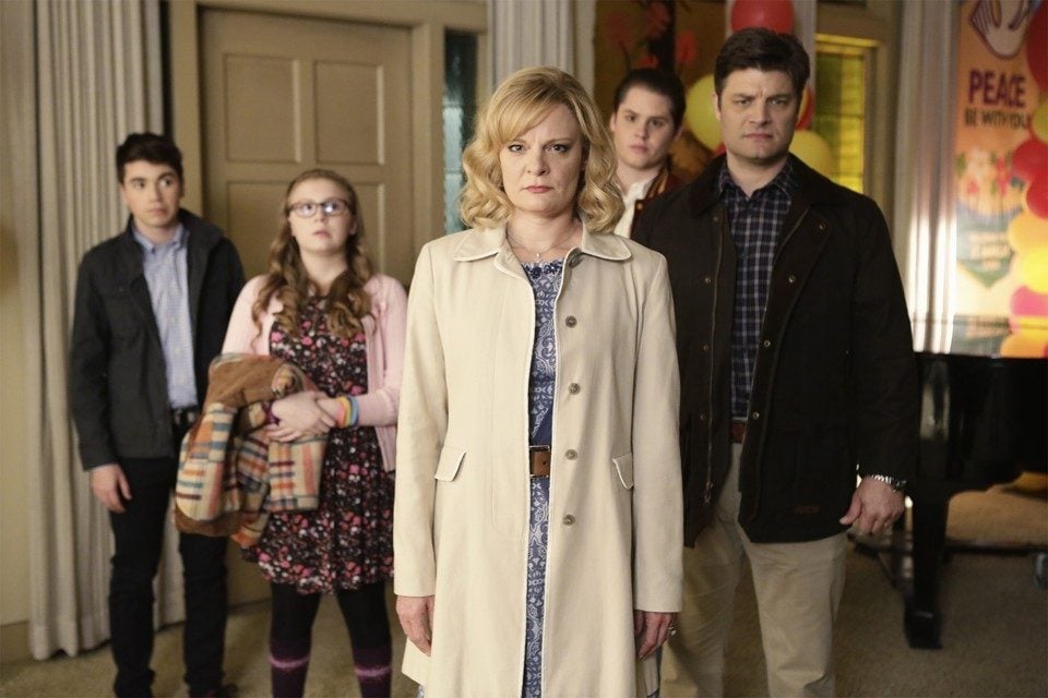 The cast of the Real O'Neals stand in front of a door in formation