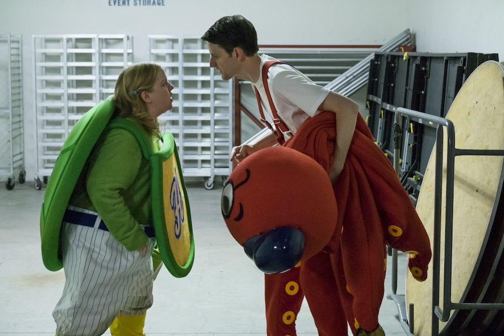 A woman in a green costume and a man in a red one yell at one another