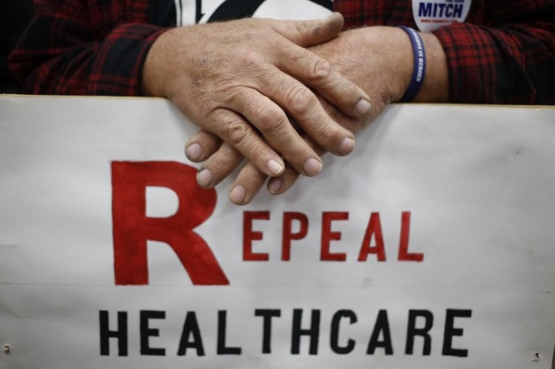 A Mitch McConnell supporter at a Kentucky rally holding a sign calling for the repeal fo the Affordable Care Act
