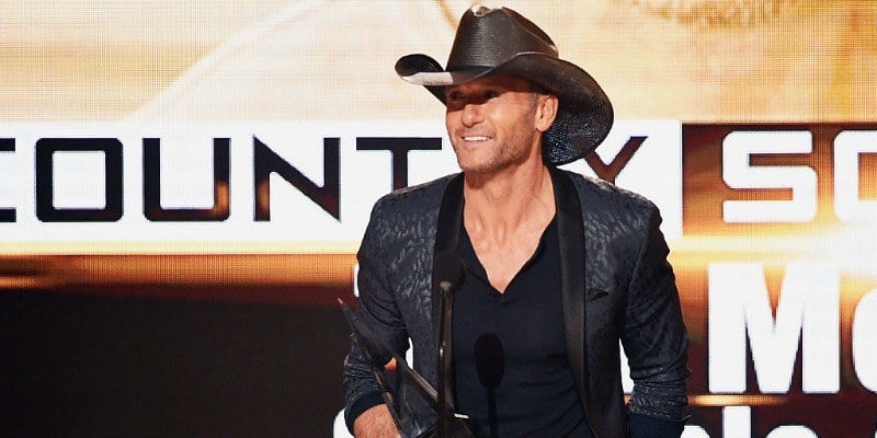 Tim McGraw is on stage holding an award.