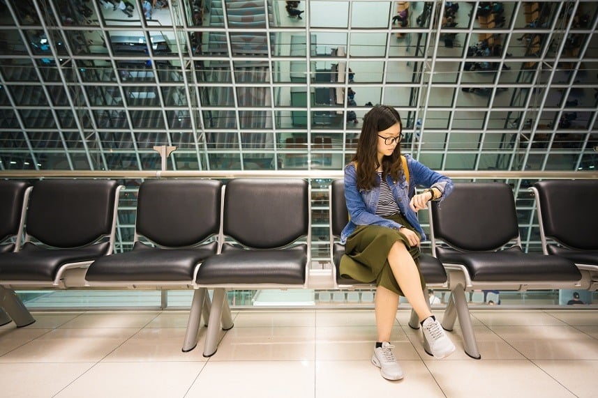 girl looking at her watch, waiting to board airplane