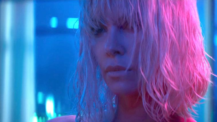 Charlize Theron in a blue room with pink light on her blond hair in Atomic Blonde