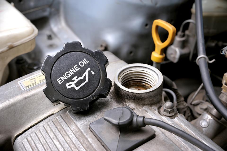 An unscrewed engine oil cap