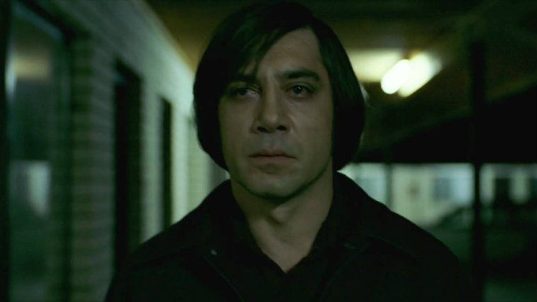 Javier Bardem standing outside looking upset in No Country for Old Men