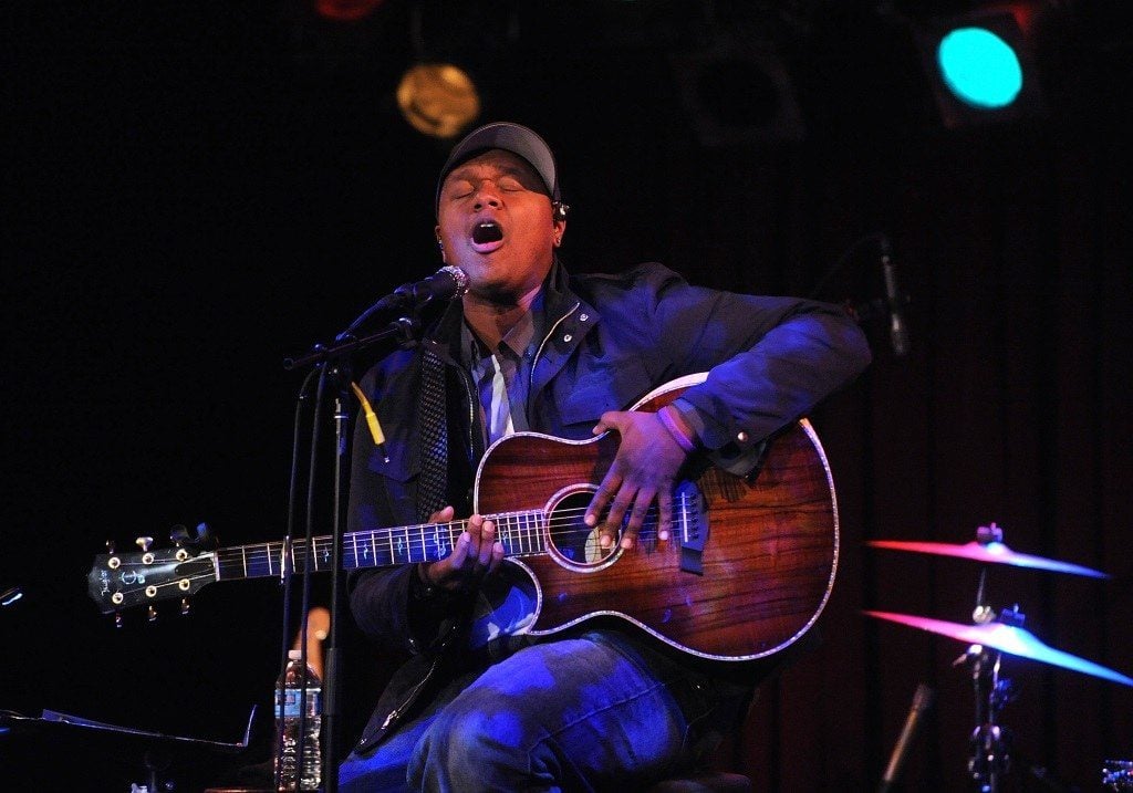 Musician Javier Colon sings and plays guitar while seated