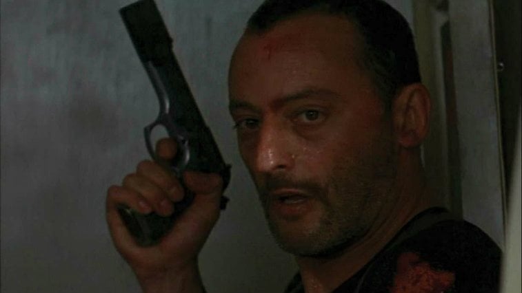 Jean Reno with a gun looking exhausted in Leon The Professional