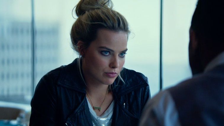 Margot Robbie with her hair up and in a black jacket in the film Focus