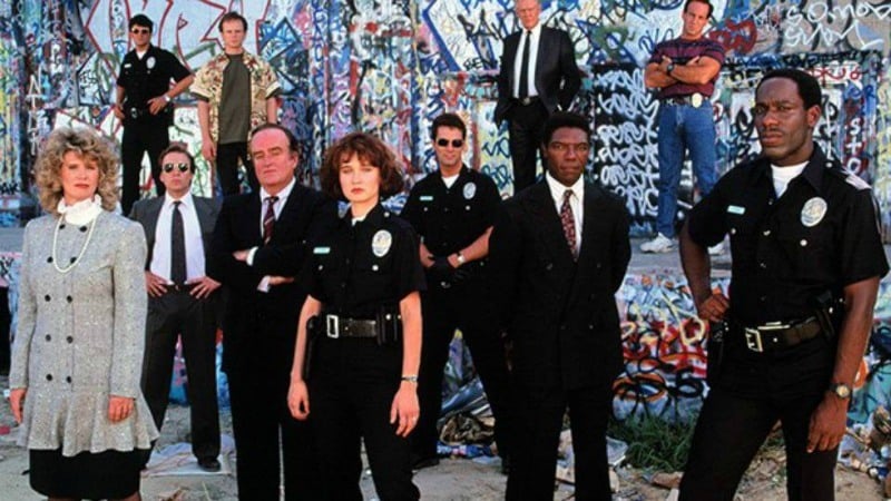Group of 11 people some police officers standing in front of graffiti