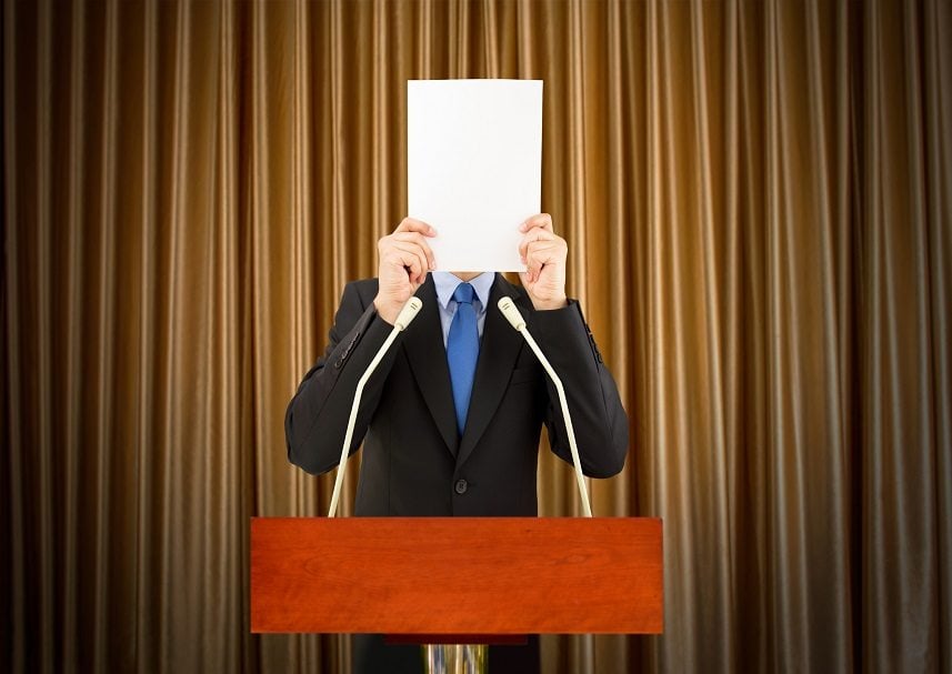 businessman with stage fright covering his face