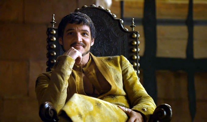 Oberyn Martell sits with his chin on his hand and smiles in a scene from 'Game of Thrones.'