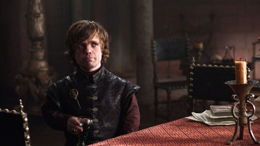 Tyrion Lannister holds a glass of wine and looks amused in a scene from 'Game of Thrones.'
