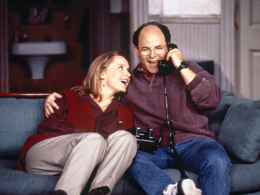 Susan (Heidi Swedberg) leans on George's (Jason Alexander) shoulder as he talks on the phone in a scene from 'Seinfeld'