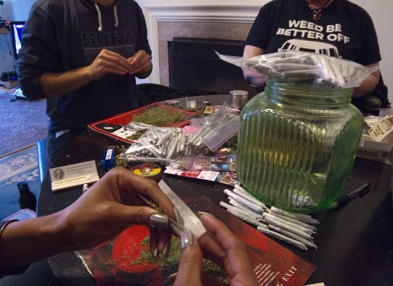 Members of the DC Marijuana Coalition roll joints at a table