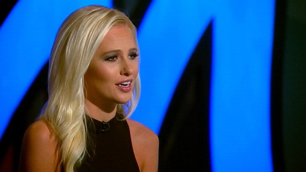 Tomi Lahren looks to her right sitting at a news desk
