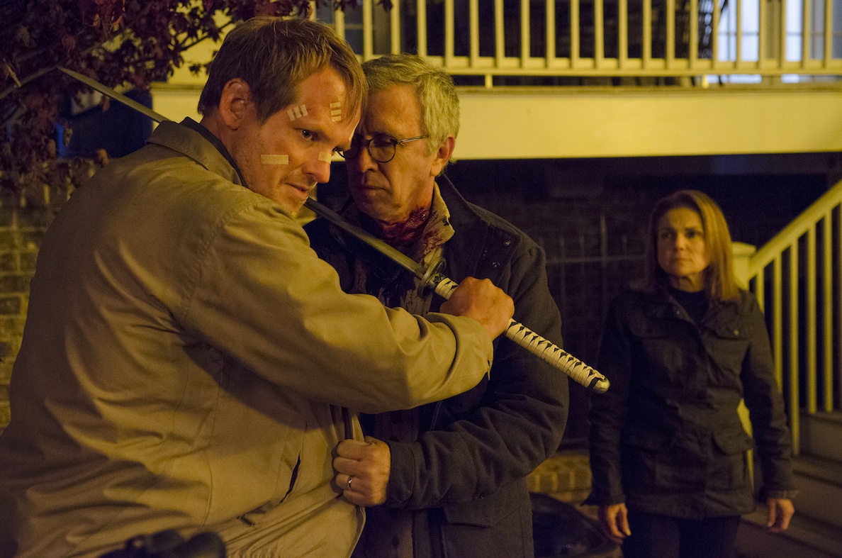 Pete holds a katana to Reg's throat as Deanna watches in a scene from 'The Walking Dead' fifth season finale.
