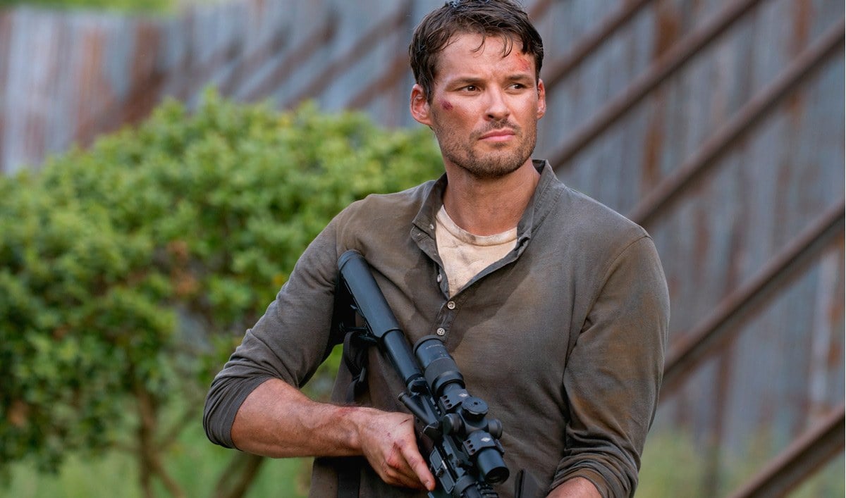 Spencer Monroe holds a gun as he walks through Alexandria in a scene from 'The Walking Dead'