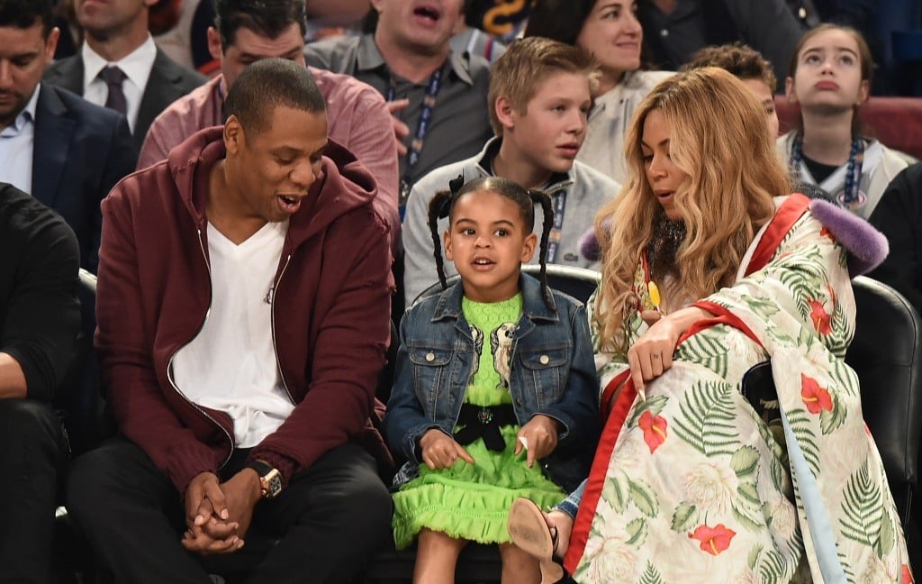 JAY-Z, Blue Ivy Carter, and Beyoncé Knowles sit court side at an NBA basketball game