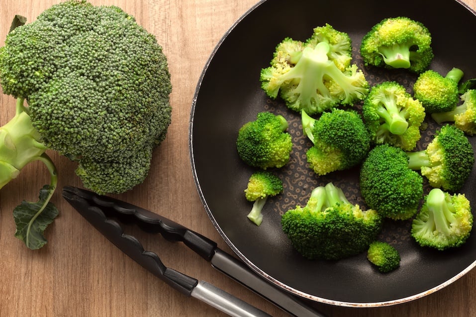 Broccoli in pan on wood kitchen table