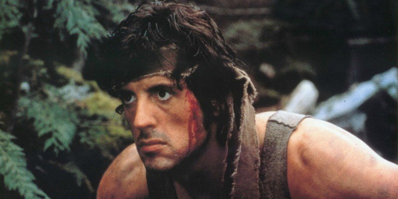 Rambo has blood trickling down his face as he is going through the woods.