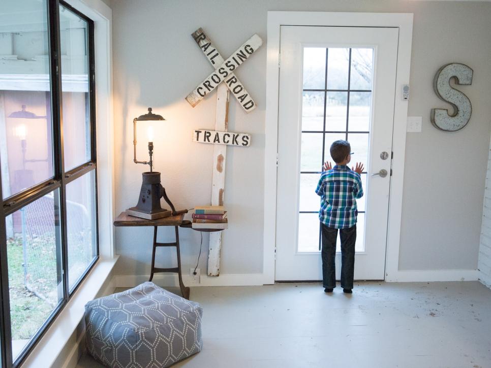 Five-year-old Julian Silva peeks into the driveway from the new side door of the family room, as seen on HGTV's Fixer Upper. Chip and Joanna Gaines rebuilt the crumbling wall and door