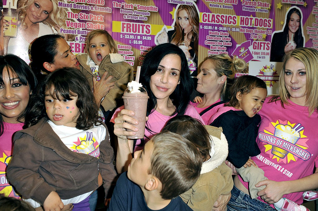 Nadya Suleman holding a milkshake, surrounded by her 14 children