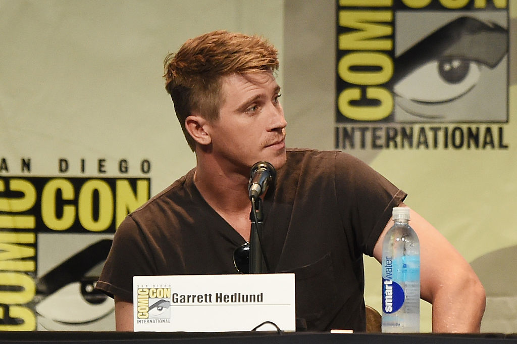 Garrett Hedlund looking to his left, speaking at a Comic-Con panel