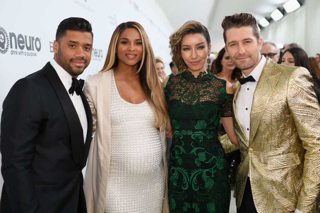 Russell Wilson, smiling next to a pregnant Ciara on the red carpet